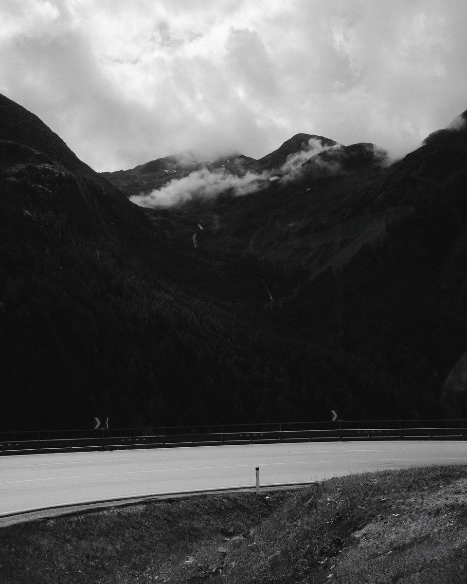Mountain road below peaks, black and white