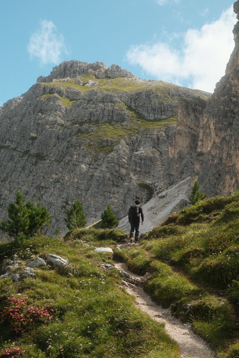 Hiker on a trail below limestone cliffs