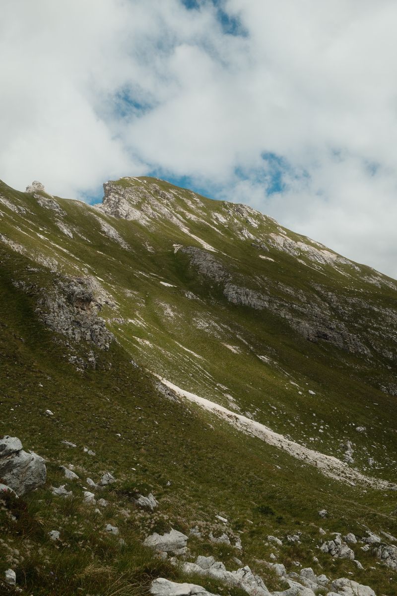 Grassy mountain ridge under clouds
